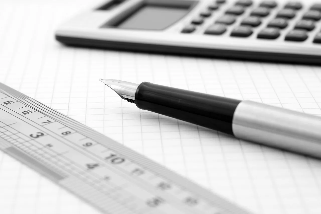 Stylo plume posé sur une feuille quadrillée à côté d'une règle